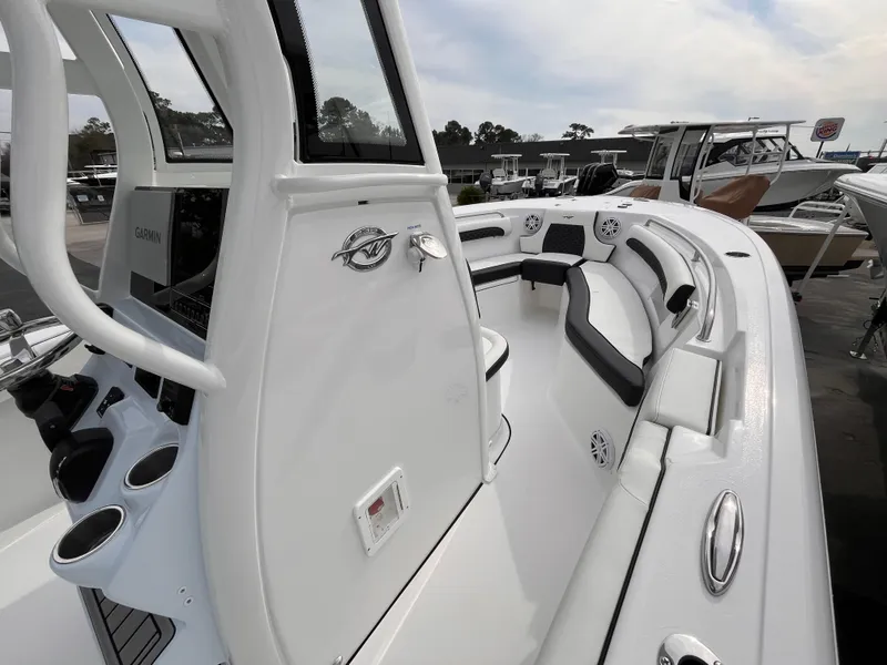 Slide: The Image of 2025 Tidewater 232 LXF boat interior with seating and console, docked outdoors. - 14