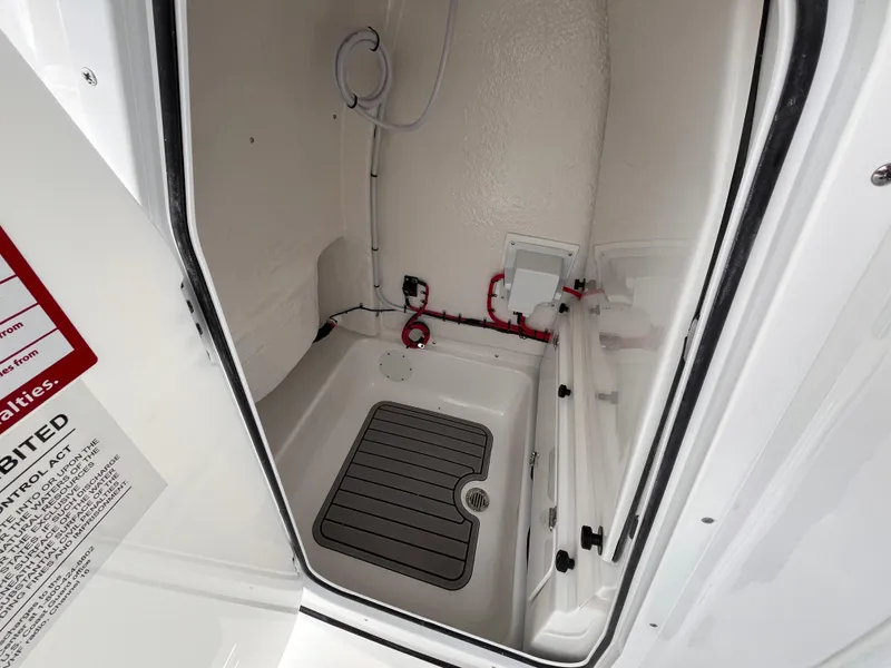 Slide: The Image of 2025 Tidewater 232 LXF boat interior compartment with plumbing and drainage system. - 16