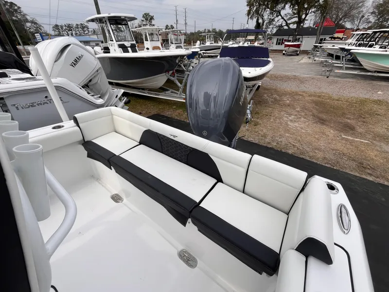Slide: The Image of 2025 Tidewater 232 LXF boat with sleek seating, displayed in a marina setting. - 6