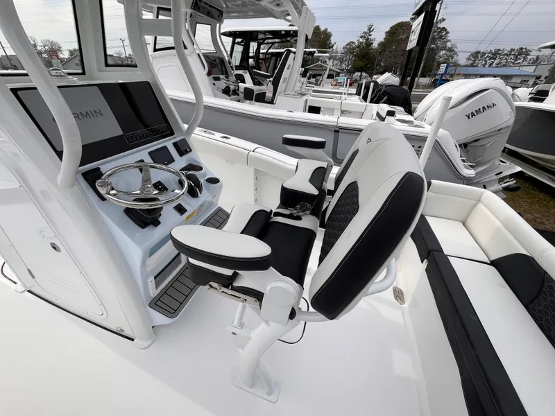 Slide: The Image of 2025 Tidewater 232 LXF boat interior with helm, seating, and Yamaha engine. - 7