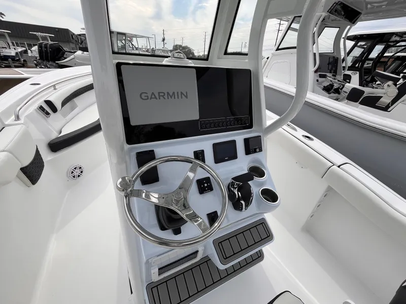Slide: The Image of 2025 Tidewater 232 LXF boat console with Garmin display and steering wheel. - 8