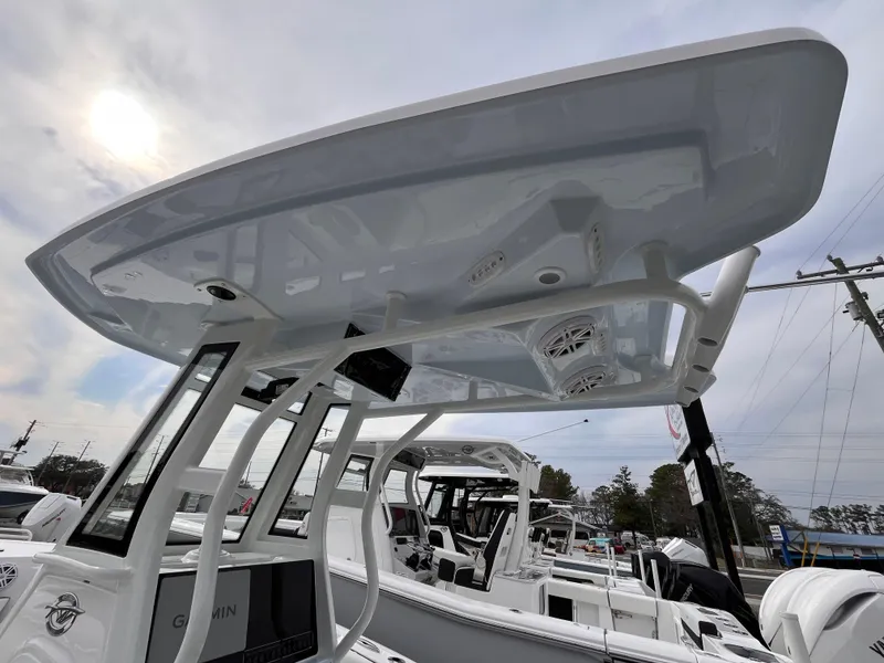 Slide: The Image of 2025 Tidewater 232 LXF boat with T-top and electronics, docked under a cloudy sky. - 9
