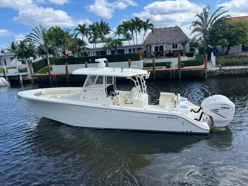 The Image of 2020 Cobia 350 boat on water, with Yamaha engine, near waterfront homes and palm trees. - 0