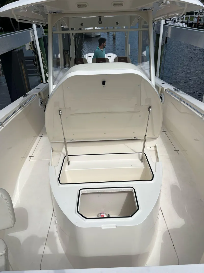 Slide: The Image of 2020 Cobia 350 boat with open storage compartment, docked by the water. - 12