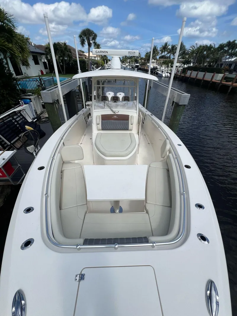 Slide: The Image of 2020 Cobia 350 boat with spacious deck, docked in a scenic canal setting. - 13