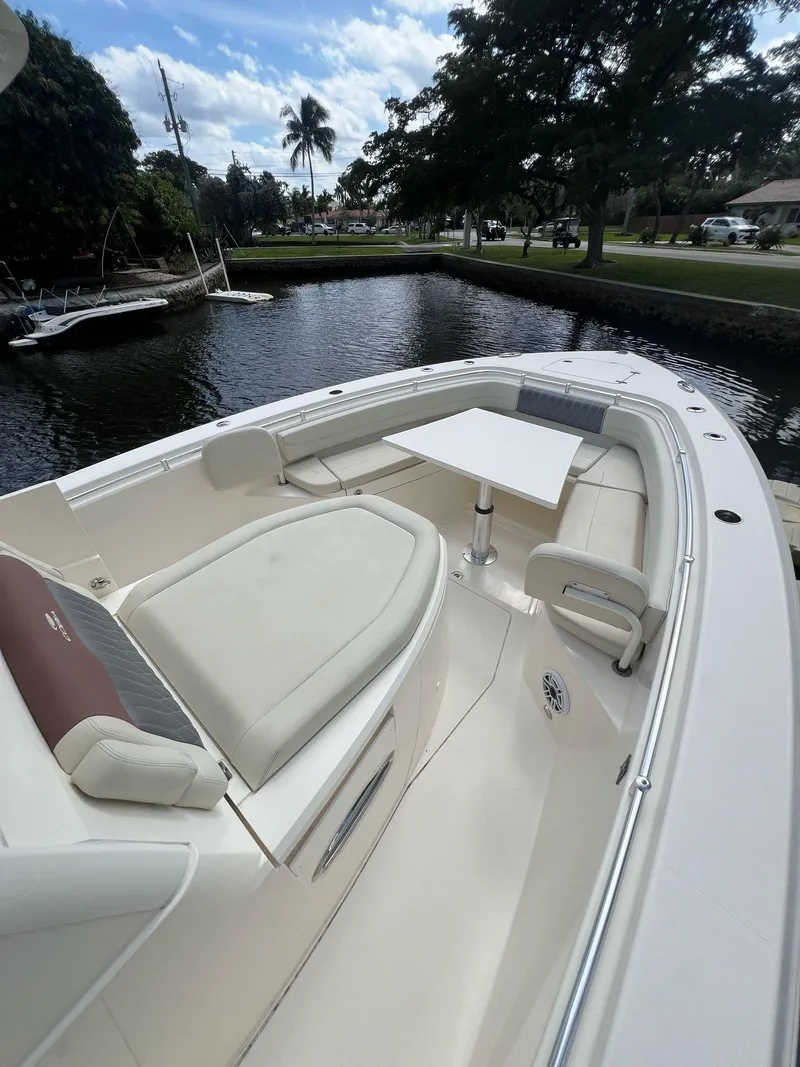 Slide: The Image of 2020 Cobia 350 boat with spacious seating and table on a calm waterway. - 15