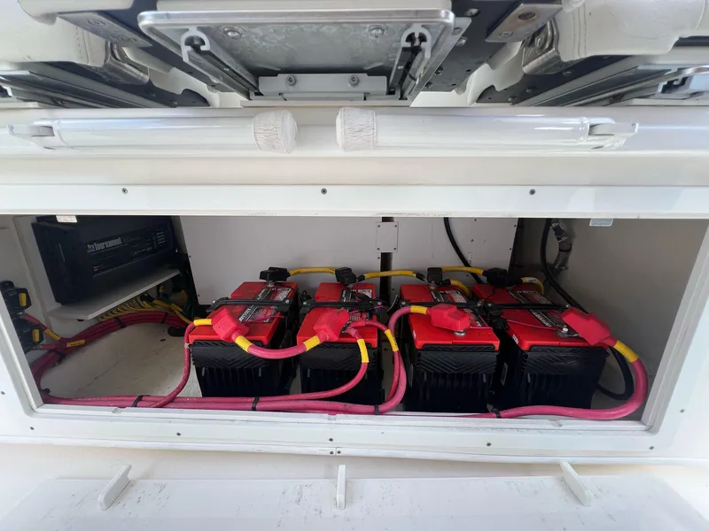 Slide: The Image of Battery compartment of 2020 Cobia 350 boat with multiple red batteries and wiring. - 16