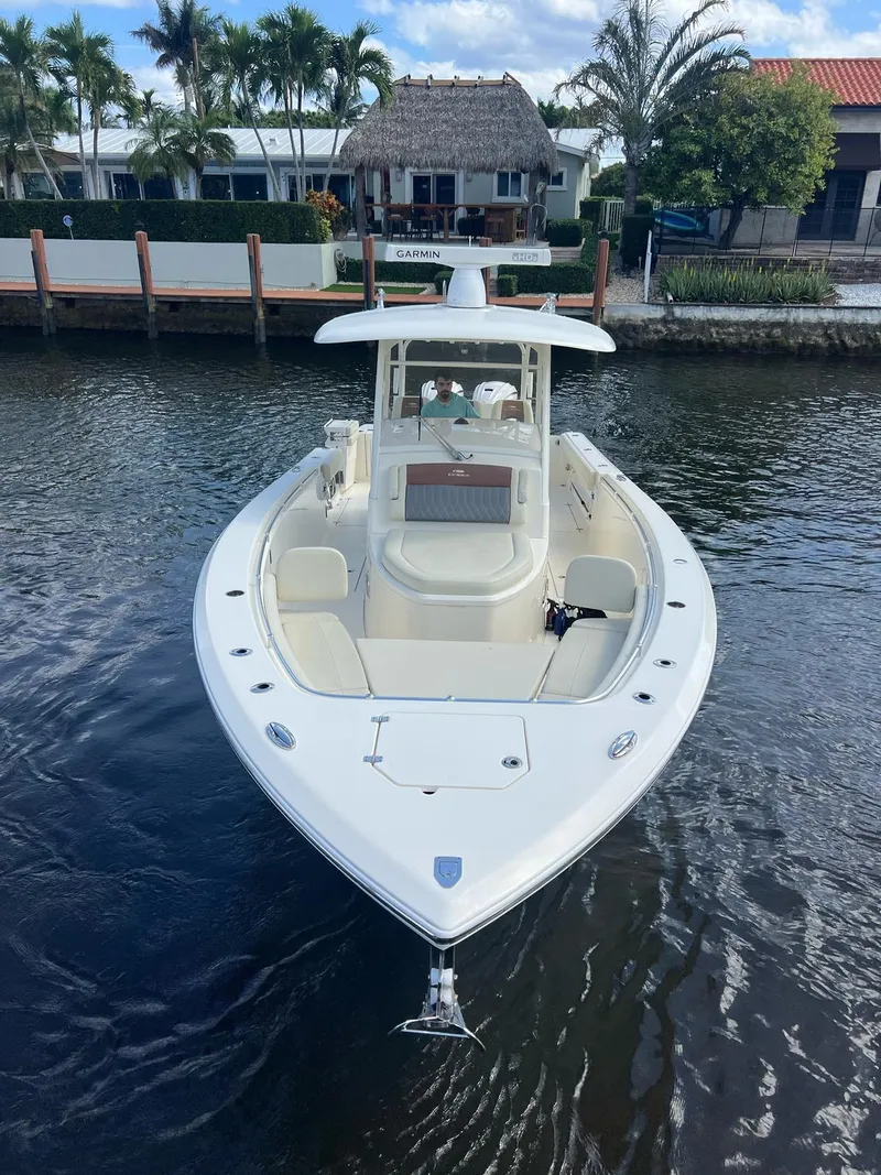 Slide: The Image of 2020 Cobia 350 boat docked on a calm waterway, surrounded by tropical scenery. - 2