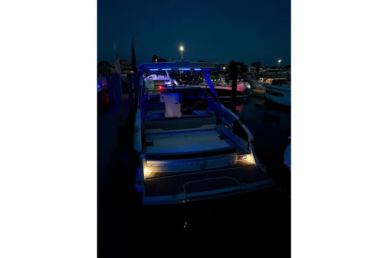 Slide: The Image of 2025 Cobalt A29 boat illuminated at night in a marina setting. - 28