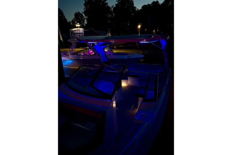 Slide: The Image of 2025 Cobalt A29 boat illuminated with blue lights at night. - 31