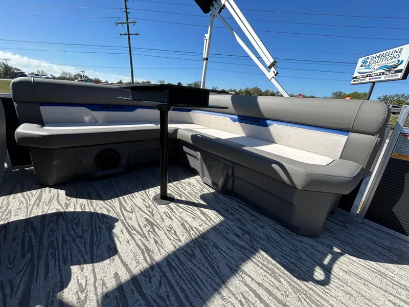 Slide: The Image of 2025 Armada Zen Z 168 boat interior with gray seating and table, under clear blue sky. - 6