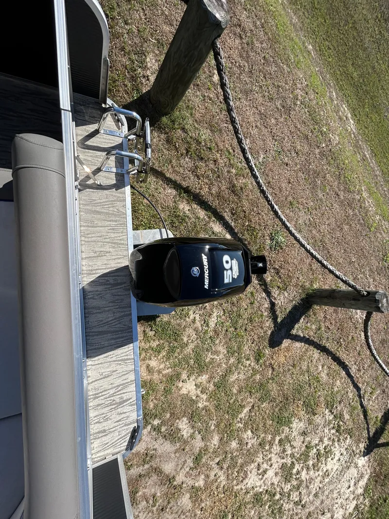 Slide: The Image of 2025 Armada Zen Z 168 boat with outboard motor, docked on grassy shore. - 8