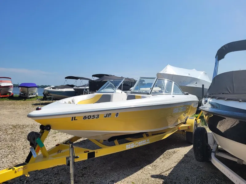 Slide: The Image of 2002 Moomba Outback LSV boat on trailer, parked among other boats under clear blue sky. - 3