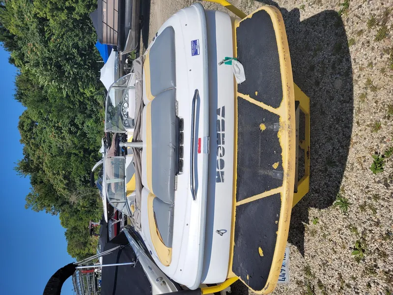 Slide: The Image of 2002 Moomba Outback LSV boat on trailer, parked outdoors with trees in background. - 4