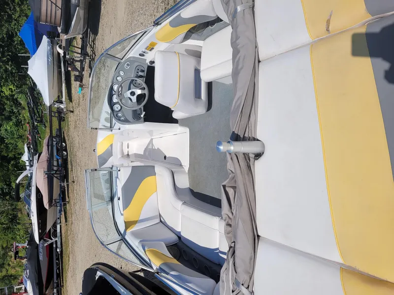 Slide: The Image of 2002 Moomba Outback LSV boat interior with yellow and gray seating, parked outdoors. - 5