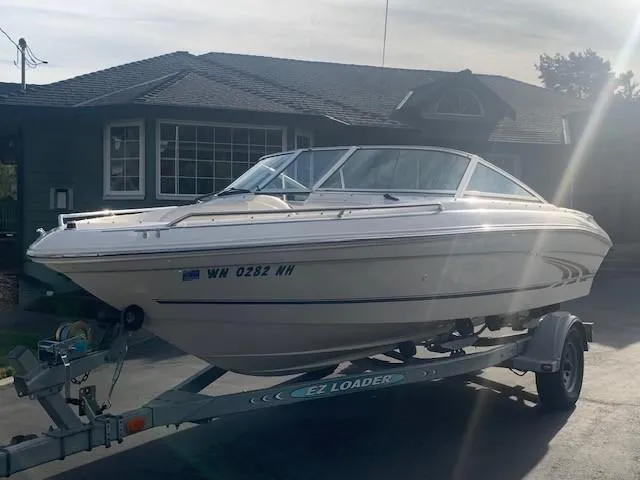Slide: The Image of 1998 Sea Ray 185 Bow Rider on trailer in front of house. - 3