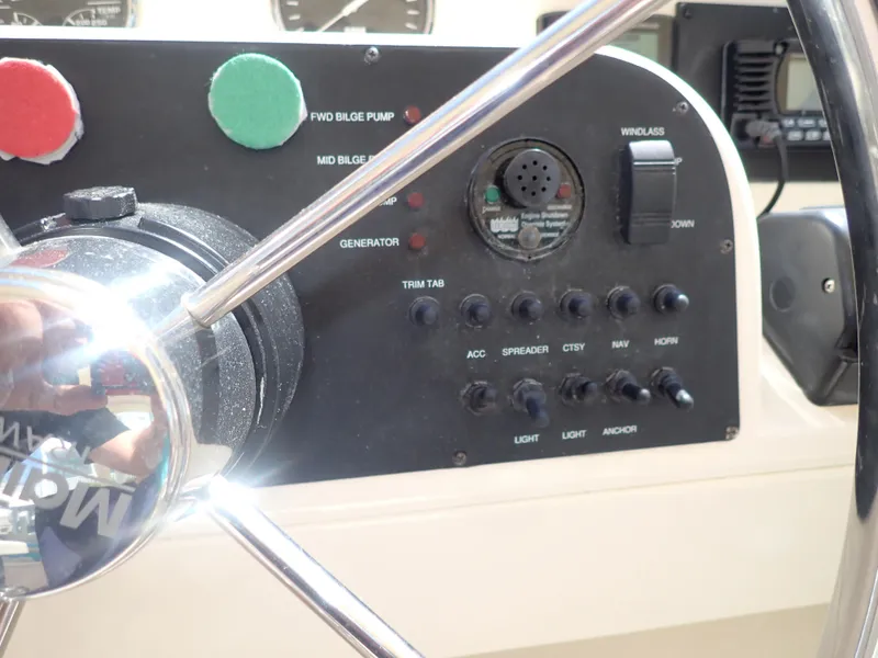 Slide: The Image of Control panel of a 2006 Mainship 34 Trawler with steering wheel and switches. - 26