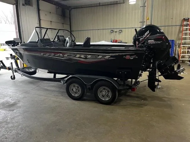 Slide: The Image of 2022 Tracker Targa 18 WT boat in a garage, featuring a Mercury outboard motor. - 4