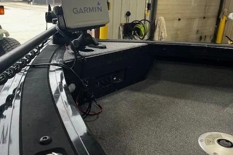 Slide: The Image of 2022 Tracker Targa 18 WT boat interior with Garmin device, showing carpeted deck and storage area. - 7