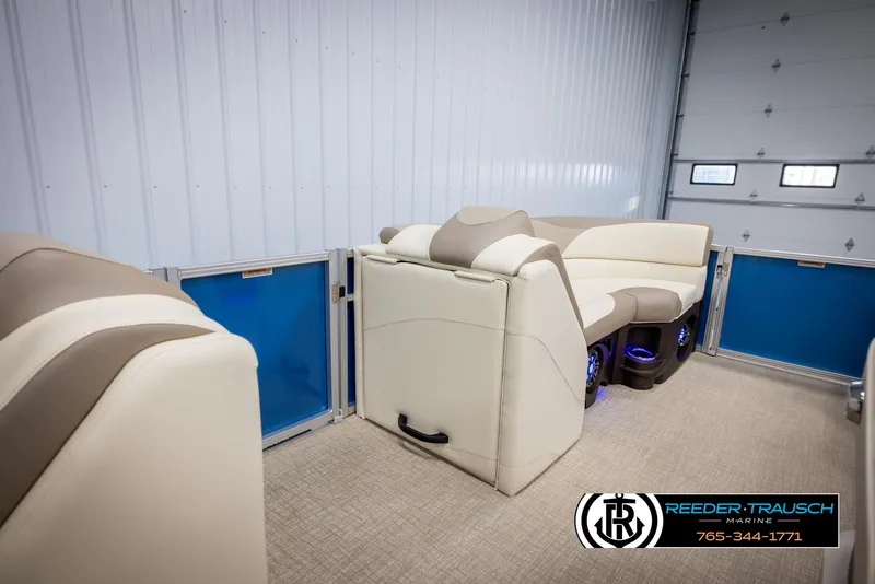 Slide: The Image of 2025 Avalon LSZ VRB boat interior with beige seating and blue accents in a garage. - 20