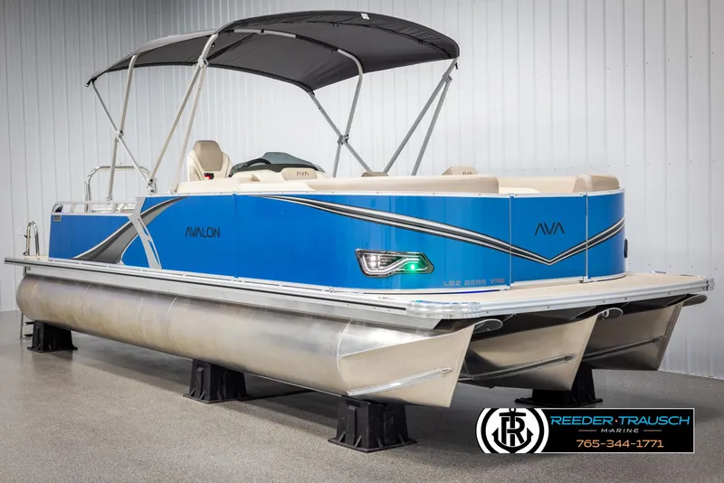 Slide: The Image of 2025 Avalon LSZ VRB pontoon boat with blue exterior and canopy, displayed indoors. - 3