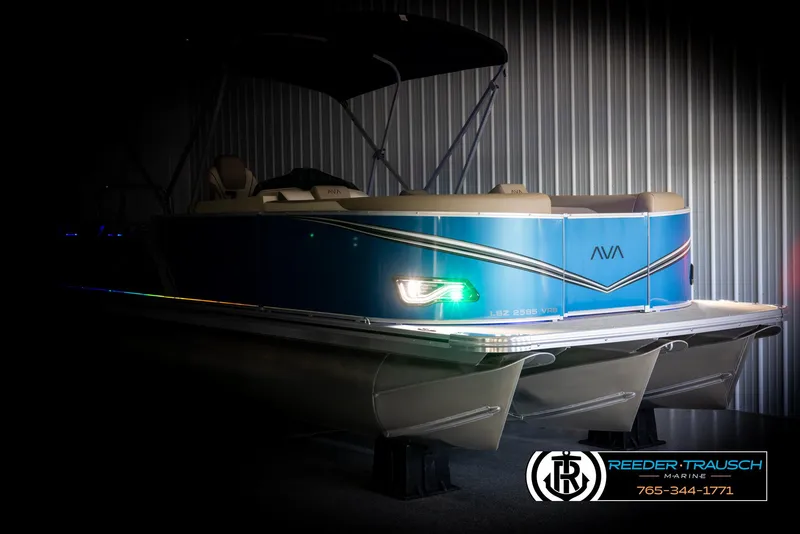 Slide: The Image of 2025 Avalon LSZ VRB pontoon boat in a dimly lit showroom. - 4