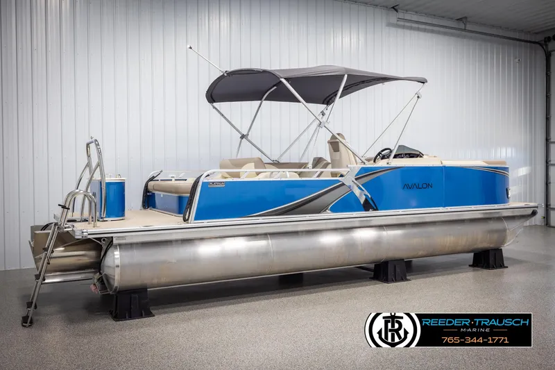 Slide: The Image of 2025 Avalon LSZ VRB pontoon boat with blue exterior and canopy in showroom. - 6