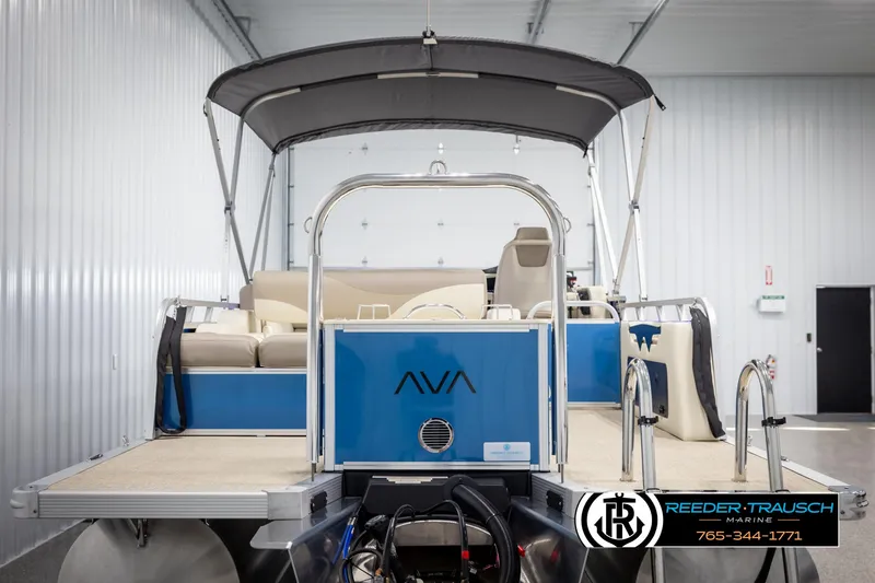 Slide: The Image of 2025 Avalon LSZ VRB pontoon boat in a showroom, featuring a blue and beige design. - 7