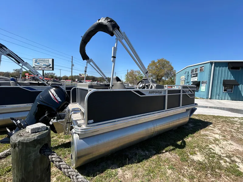 Slide: The Image of 2025 Armada Z-168 pontoon boat with Mercury outboard motor, parked outdoors. - 15