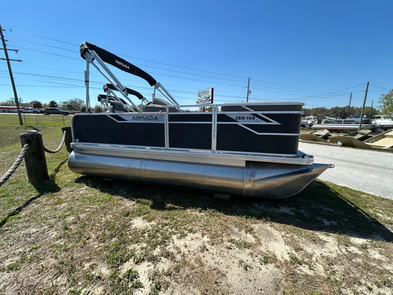 Slide: The Image of 2025 Armada Z-168 pontoon boat on grassy area under clear blue sky. - 2