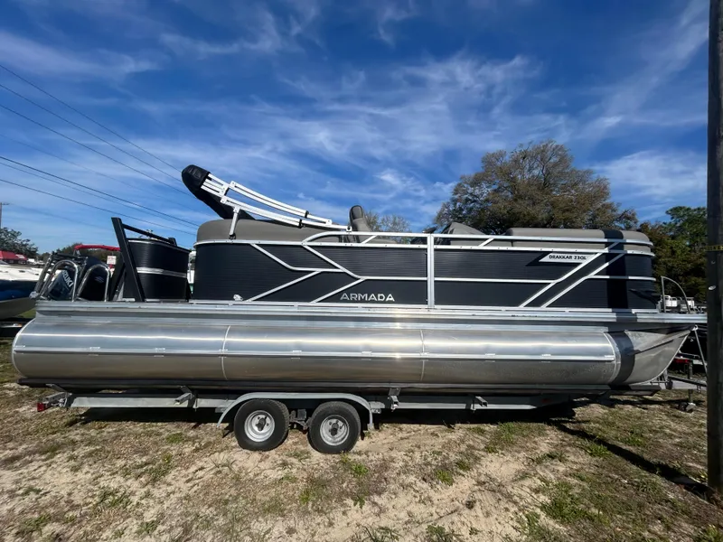 The Image of 2025 Armada Drakkar 23QL pontoon boat on trailer, parked outdoors under blue sky. - 0