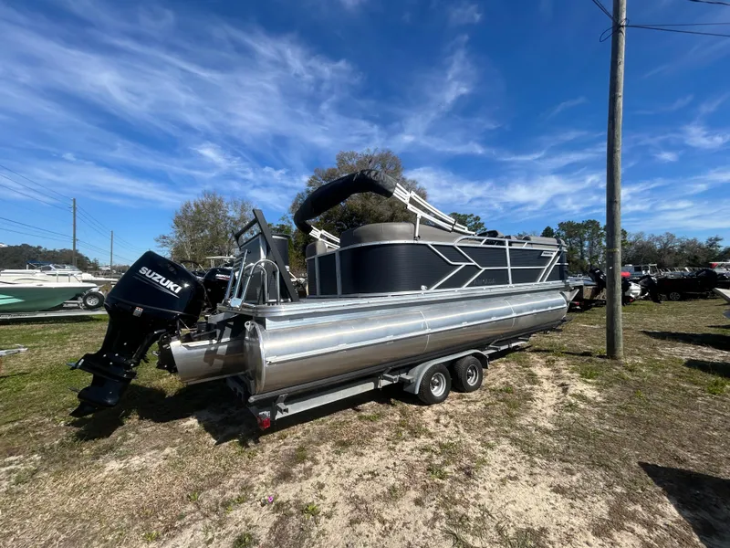 Slide: The Image of 2025 Armada Drakkar 23QL pontoon boat with Suzuki outboard motor on trailer. - 2