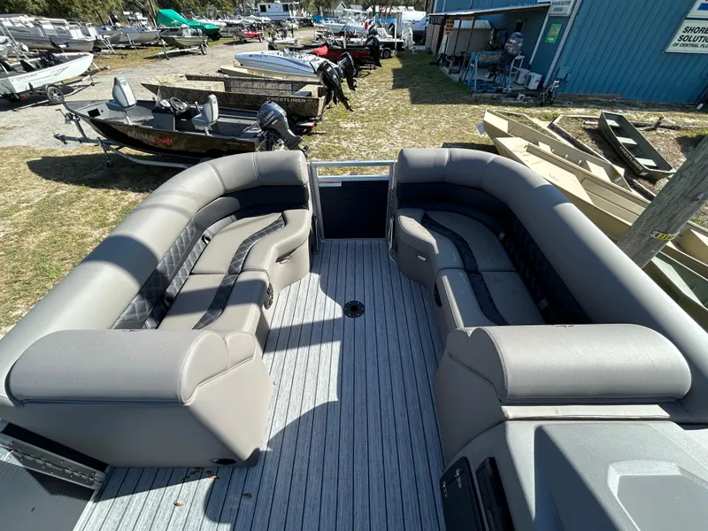 Slide: The Image of 2025 Armada Drakkar 23QL boat interior with spacious seating, docked outdoors. - 7