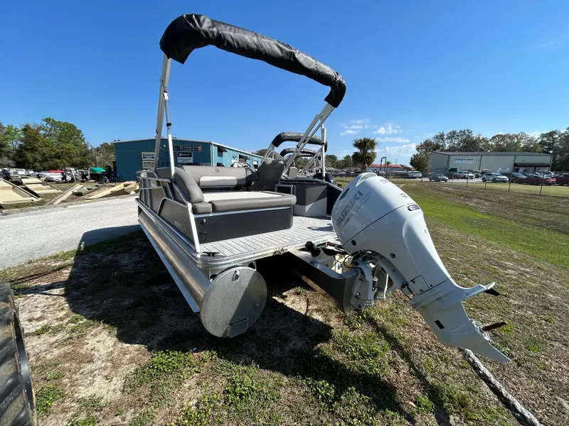 Slide: The Image of 2025 Armada Saphir 21SB pontoon boat with outboard motor, parked on grass under clear sky. - 14