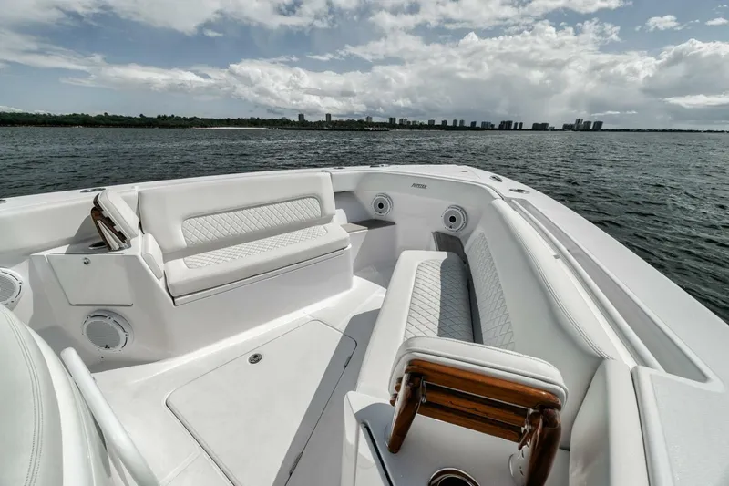 Slide: The Image of 2023 Jupiter 40 boat interior with white seating, on a calm sea under a cloudy sky. - 17