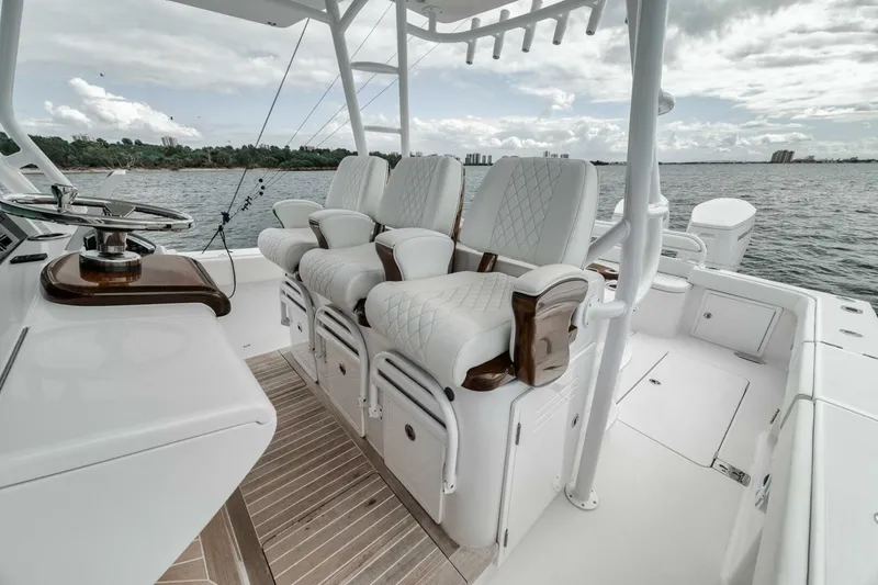 Slide: The Image of 2023 Jupiter 40 boat interior with luxurious seating and steering, overlooking calm waters. - 26