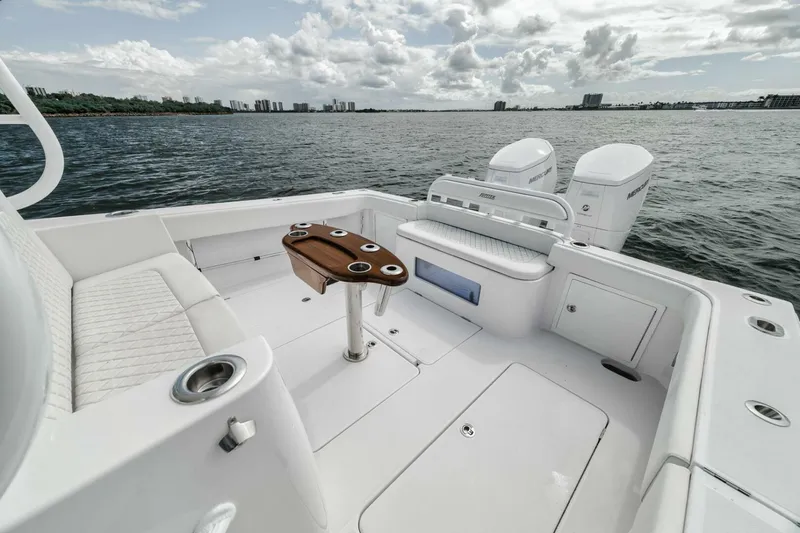 Slide: The Image of 2023 Jupiter 40 boat deck with seating, table, and twin engines on a calm sea. - 28