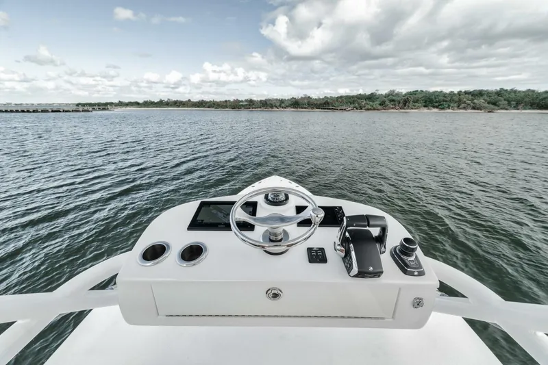 Slide: The Image of 2023 Jupiter 40 boat helm with steering wheel, controls, and ocean view. - 41