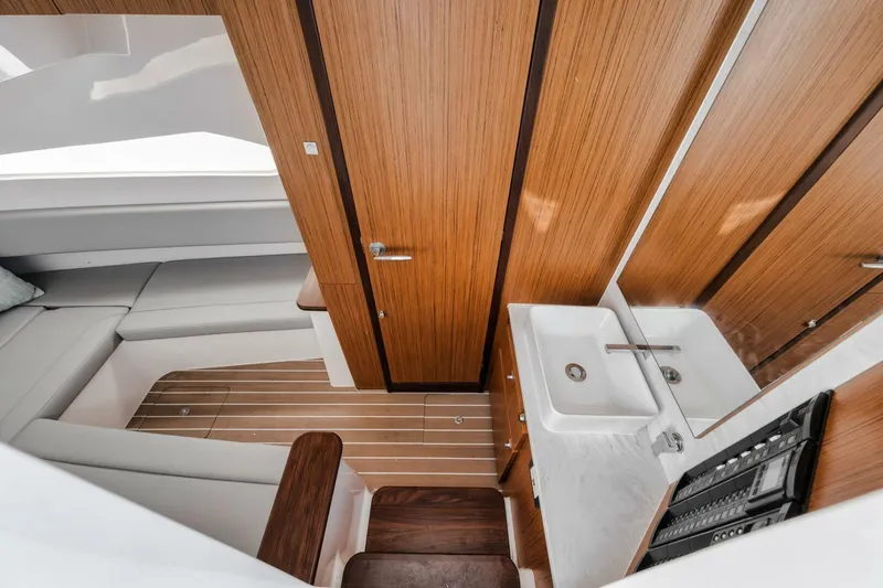 Slide: The Image of 2023 Jupiter 40 yacht interior with wood finish, featuring a compact bathroom and seating area. - 43