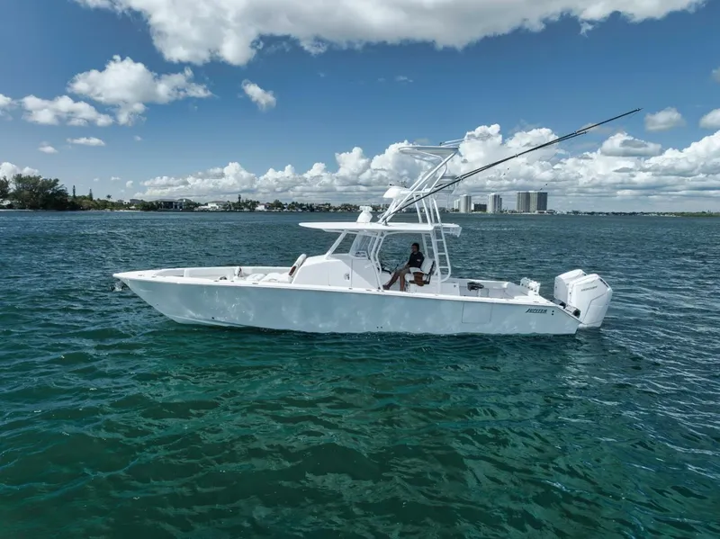 Slide: The Image of 2023 Jupiter 40 boat on clear blue water under a partly cloudy sky. - 5