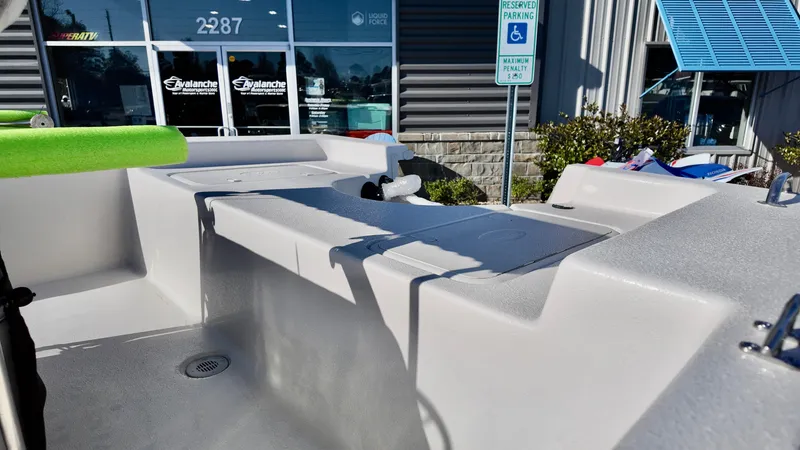 Slide: The Image of 2025 Carolina Skiff EV180 Sea Skiff boat interior at dealership, showcasing seating and storage. - 11