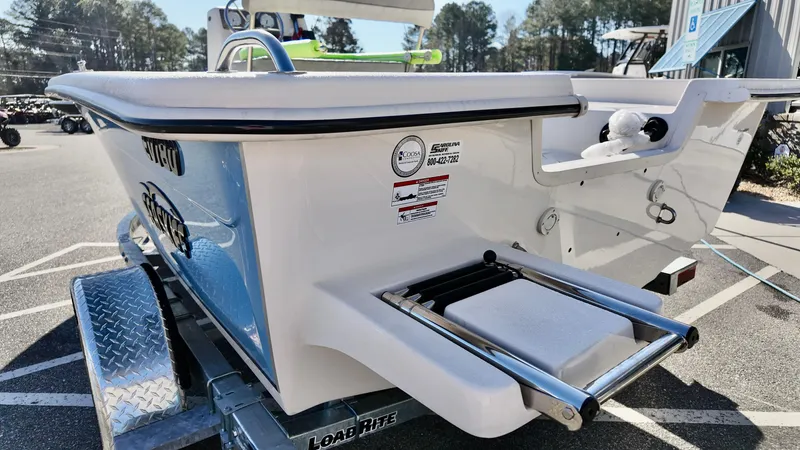 Slide: The Image of 2025 Carolina Skiff EV180 Sea Skiff on trailer, featuring rear swim platform and ladder. - 12