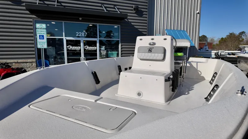 Slide: The Image of 2025 Carolina Skiff EV180 Sea Skiff boat displayed outside a dealership. - 7