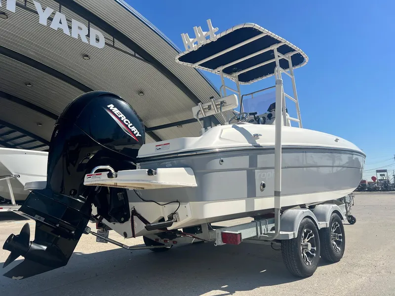 Slide: The Image of 2022 Bayliner Trophy T21Bay boat with Mercury engine on trailer, parked outdoors. - 2