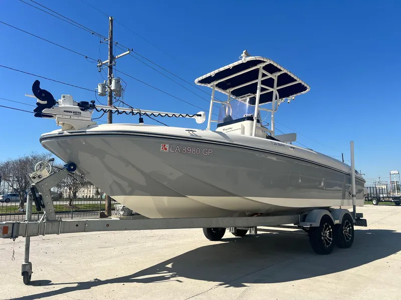 Slide: The Image of 2022 Bayliner Trophy T21Bay boat on trailer, parked outdoors under clear blue sky. - 6