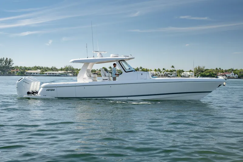 Slide: The Image of 2023 Intrepid 427 Nomad SE boat cruising on calm waters under a clear sky. - 0