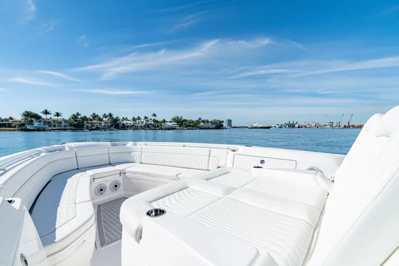 Slide: The Image of 2023 Intrepid 427 Nomad SE boat interior with white seating, ocean view, and blue sky. - 11