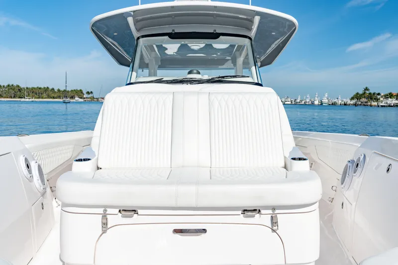 Slide: The Image of 2023 Intrepid 427 Nomad SE boat with white seating, docked on a sunny day. - 13