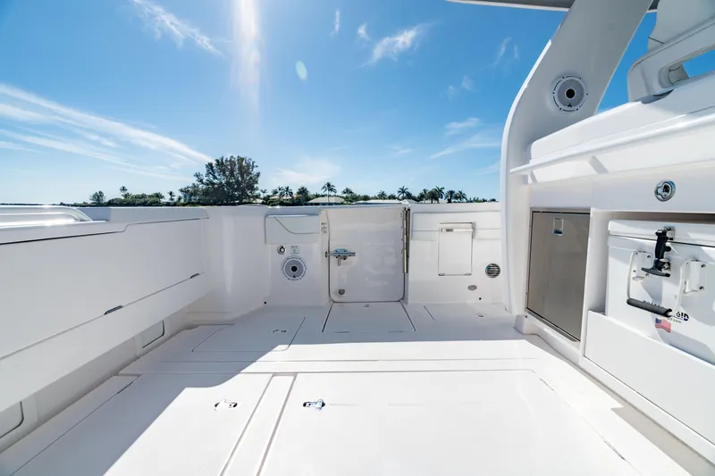 Slide: The Image of 2023 Intrepid 427 Nomad SE boat deck under clear blue sky. - 16