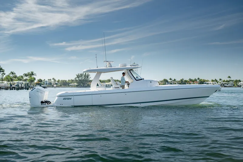 Slide: The Image of 2023 Intrepid 427 Nomad SE boat cruising on calm waters under a clear sky. - 2